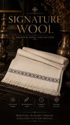 Signature Wool Shawl in cream wool with a delicate black patterned border and fringed edges, showcasing timeless elegance.